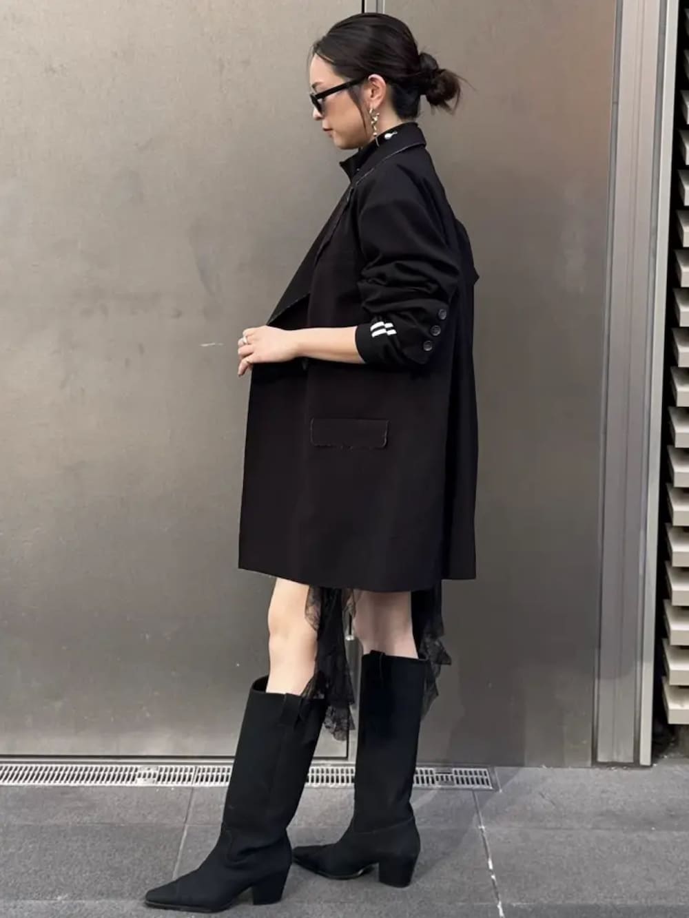 ブラック系のテーラードジャケット、ブラック系のジャージ、ブラック系のワンピースを着用したレディースの秋コーディネートの2枚目の写真