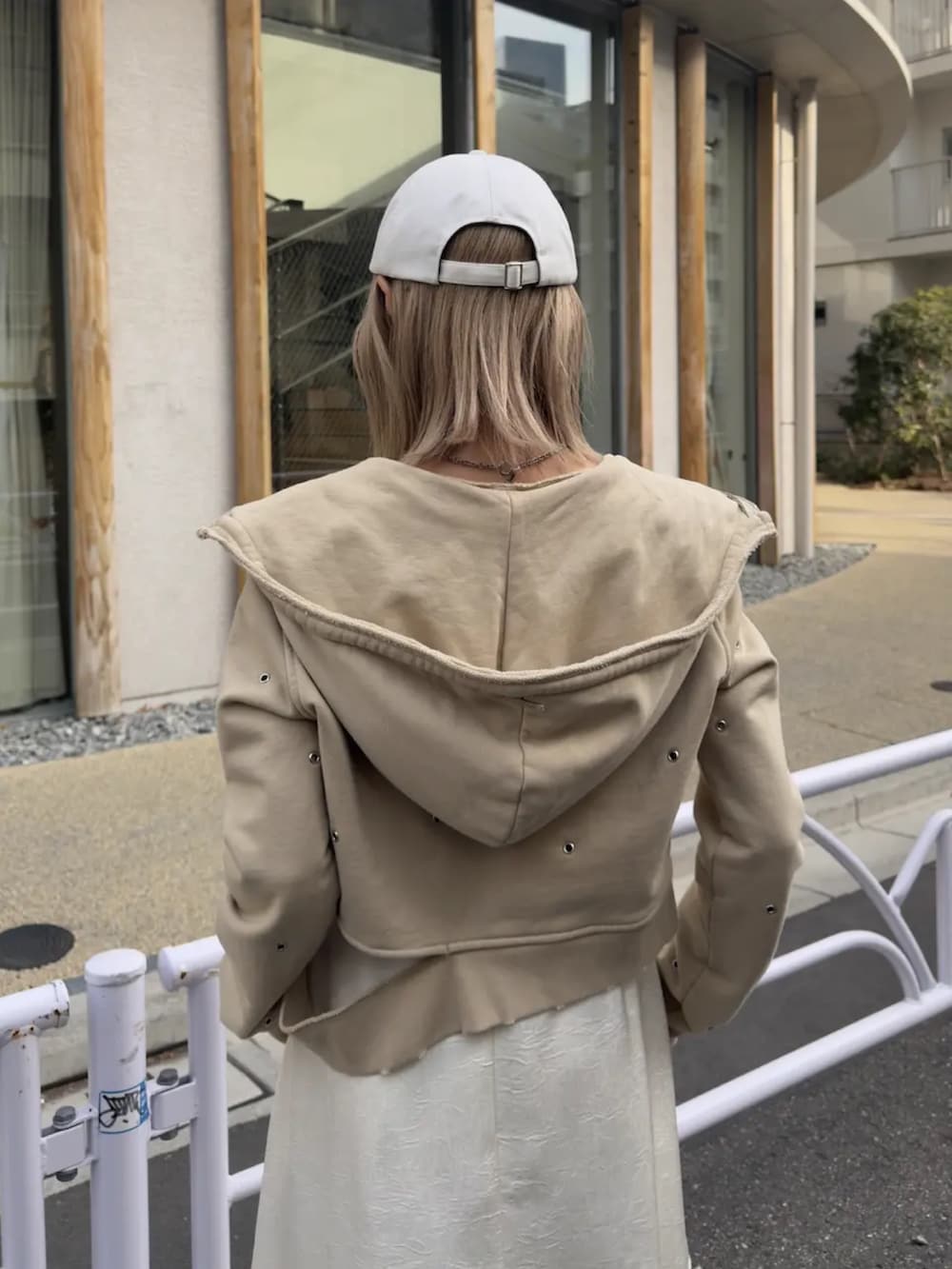 ホワイト系のタンクトップ、ベージュ系のパーカー、ホワイト系のワンピースを着用したレディースの冬コーディネートの3枚目の写真