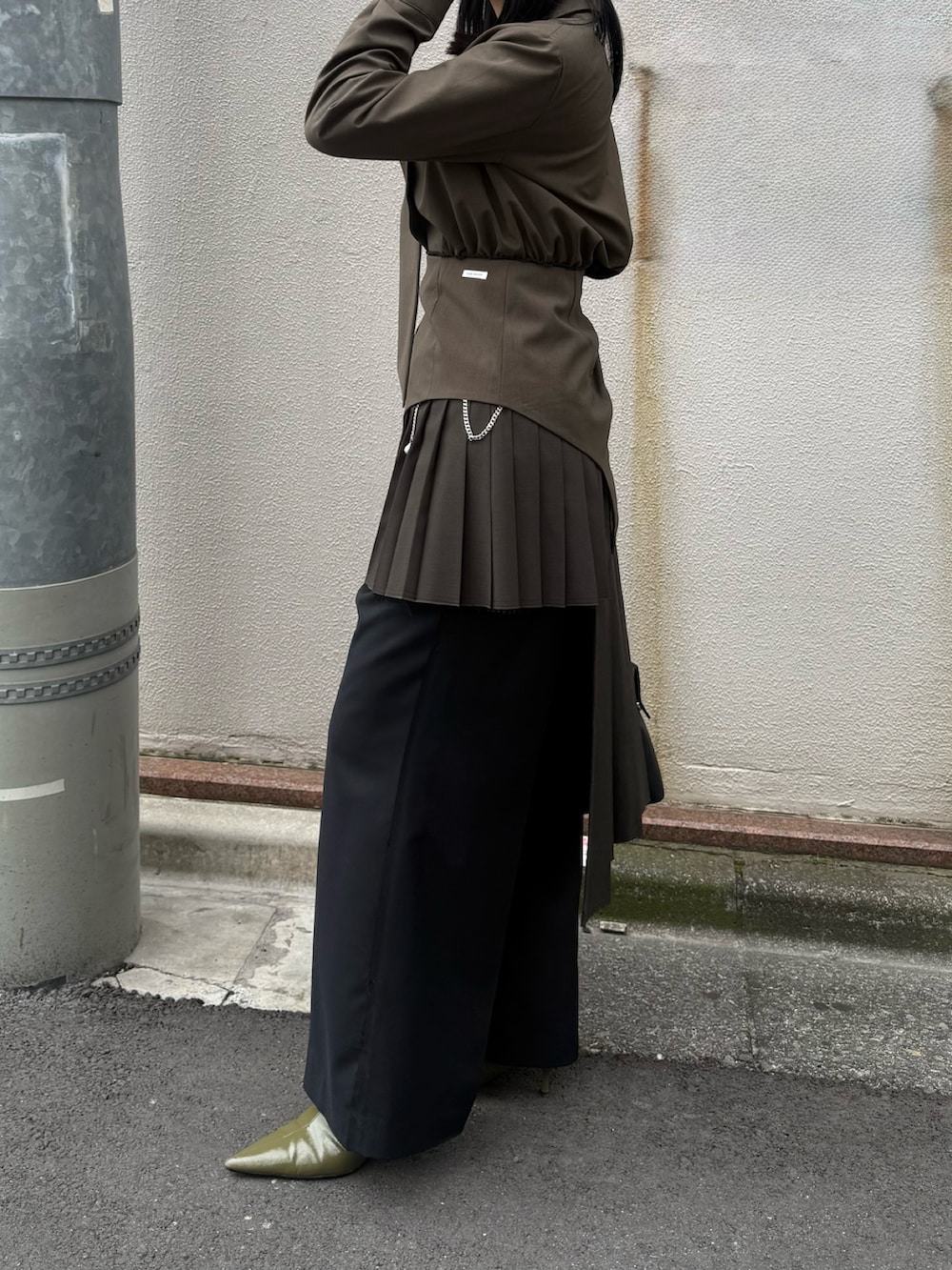 ブラック系のボストンバッグ、グリーン系のブーツ、ブラック系のスカートを着用したレディースの冬コーディネートの3枚目の写真