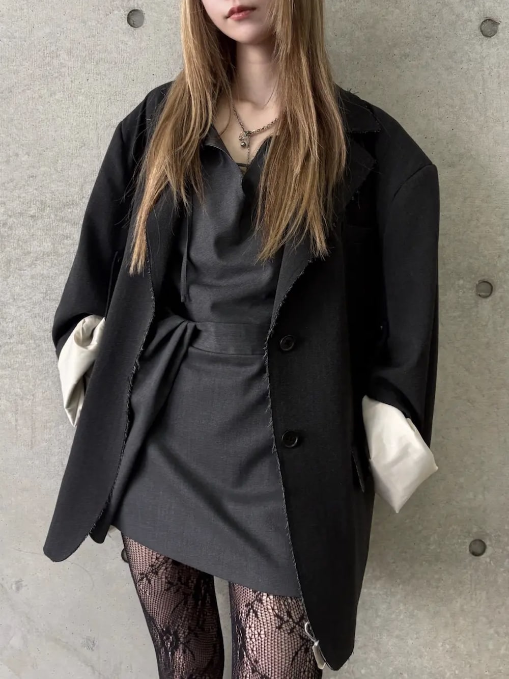 グレー系のテーラードジャケット、ブラック系のドレスを着用したレディースの冬コーディネートの4枚目の写真