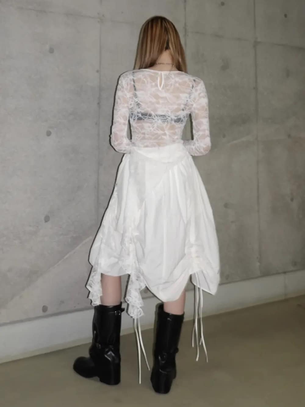 ホワイト系のTシャツ/カットソー、ホワイト系のスカート、ブラック系のブーツを着用したレディースの春コーディネートの3枚目の写真