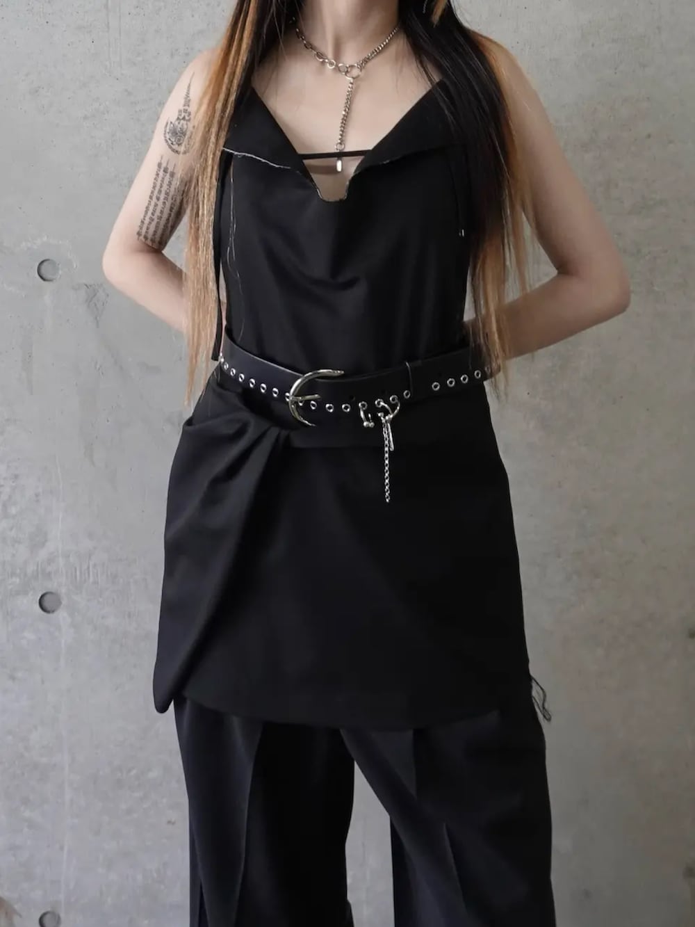 ブラック系のドレス、グレー系のスラックス、ブラック系のベルトを着用したレディースの冬コーディネートの3枚目の写真