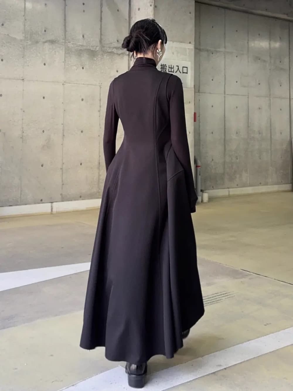 ブラック系のドレス、ブラック系のブーツを着用したレディースの冬コーディネートの2枚目の写真