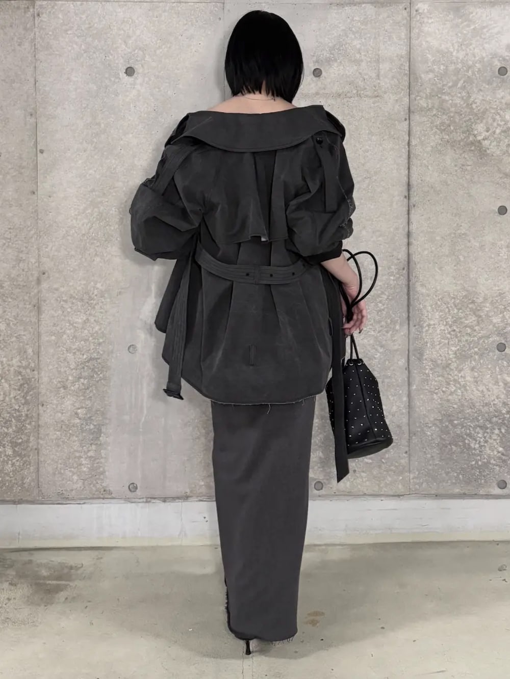 ブラック系のその他トップス、グレー系のトレンチコート、ブラック系のスカートを着用したレディースの春コーディネートの2枚目の写真