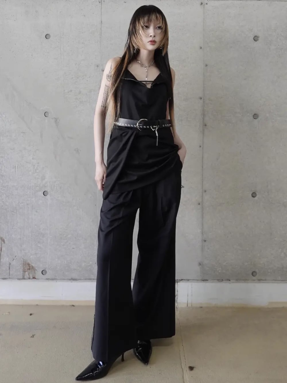 ブラック系のドレス、グレー系のスラックス、ブラック系のベルトを着用したレディースの冬コーディネートの2枚目の写真