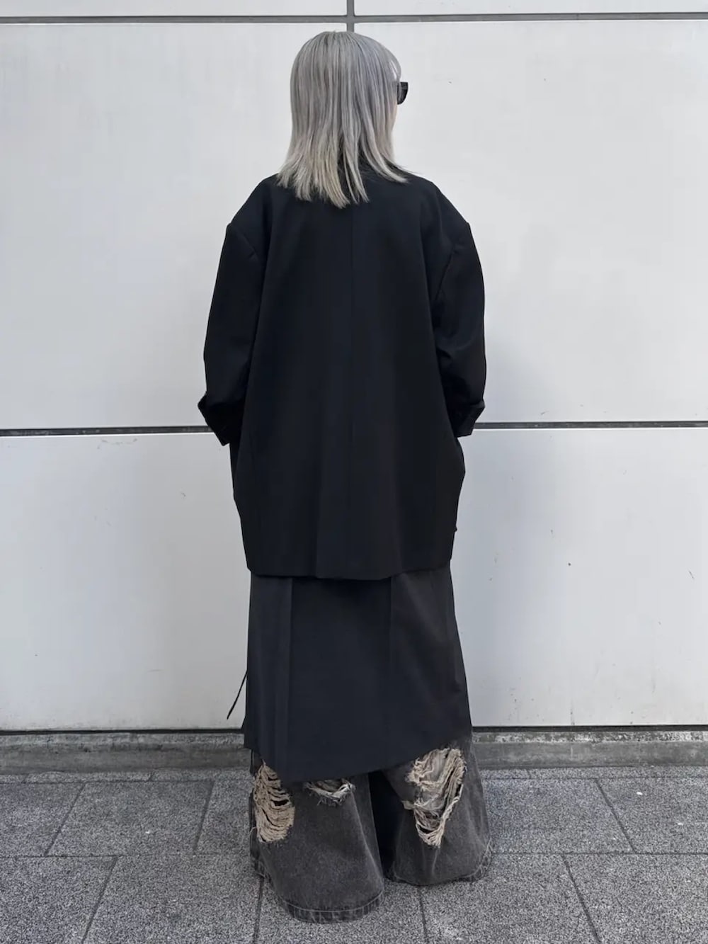 ブラック系のテーラードジャケット、ブラウン系のデニムパンツを着用したレディースの冬コーディネートの3枚目の写真