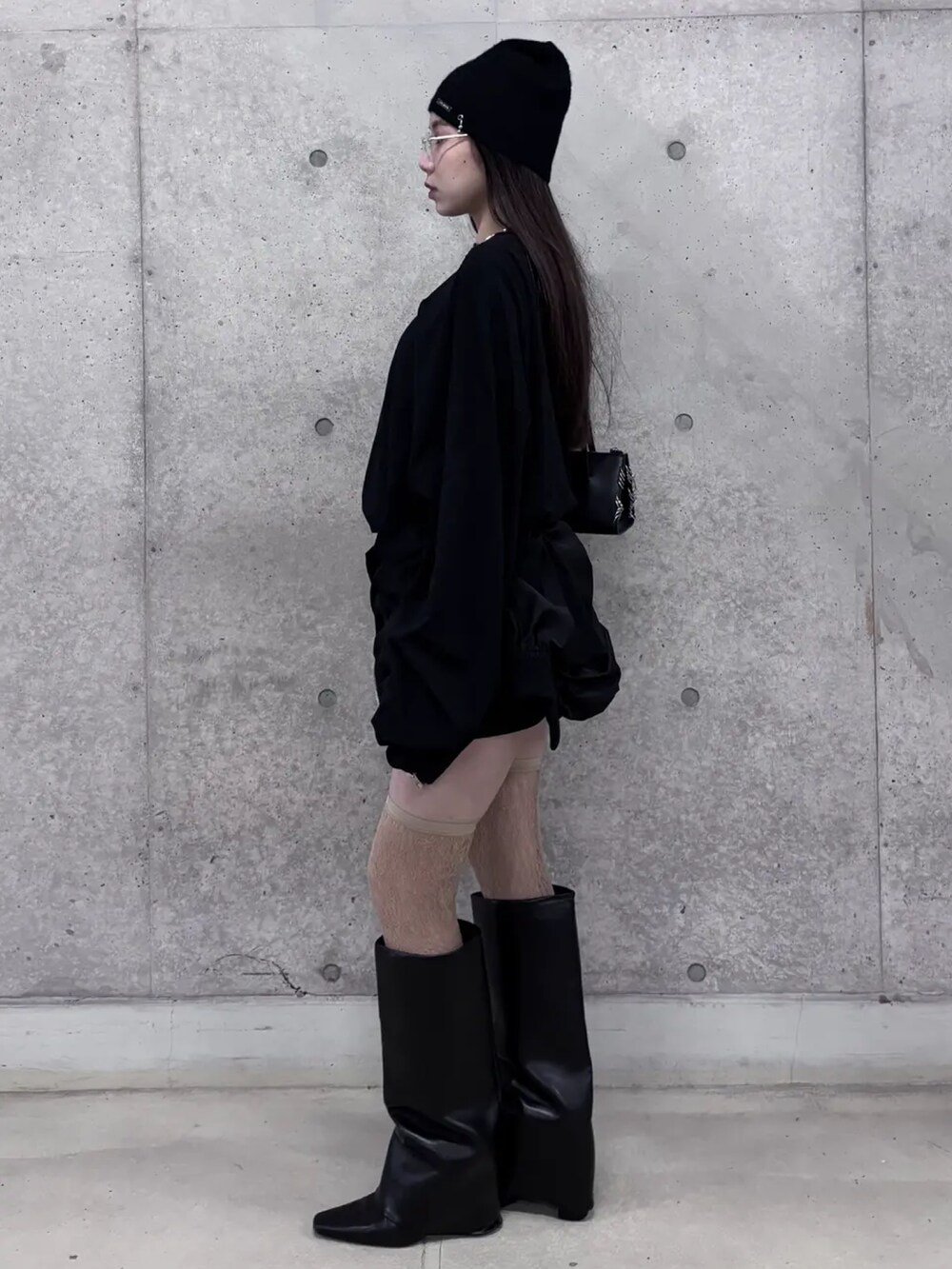 ブラック系のスカート、ブラック系のTシャツ/カットソー、ベージュ系のソックス/靴下を着用したレディースの冬コーディネートの2枚目の写真