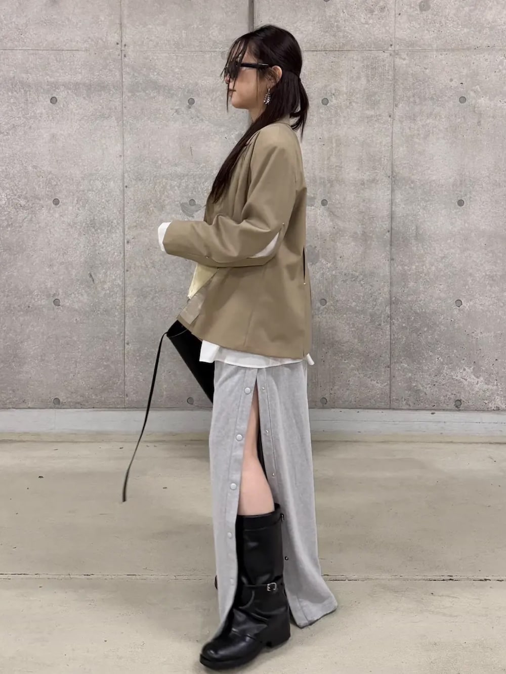 イエロー系のキャミソール、ベージュ系のテーラードジャケット、グレー系のスウェットパンツを着用したレディースの春コーディネートの2枚目の写真