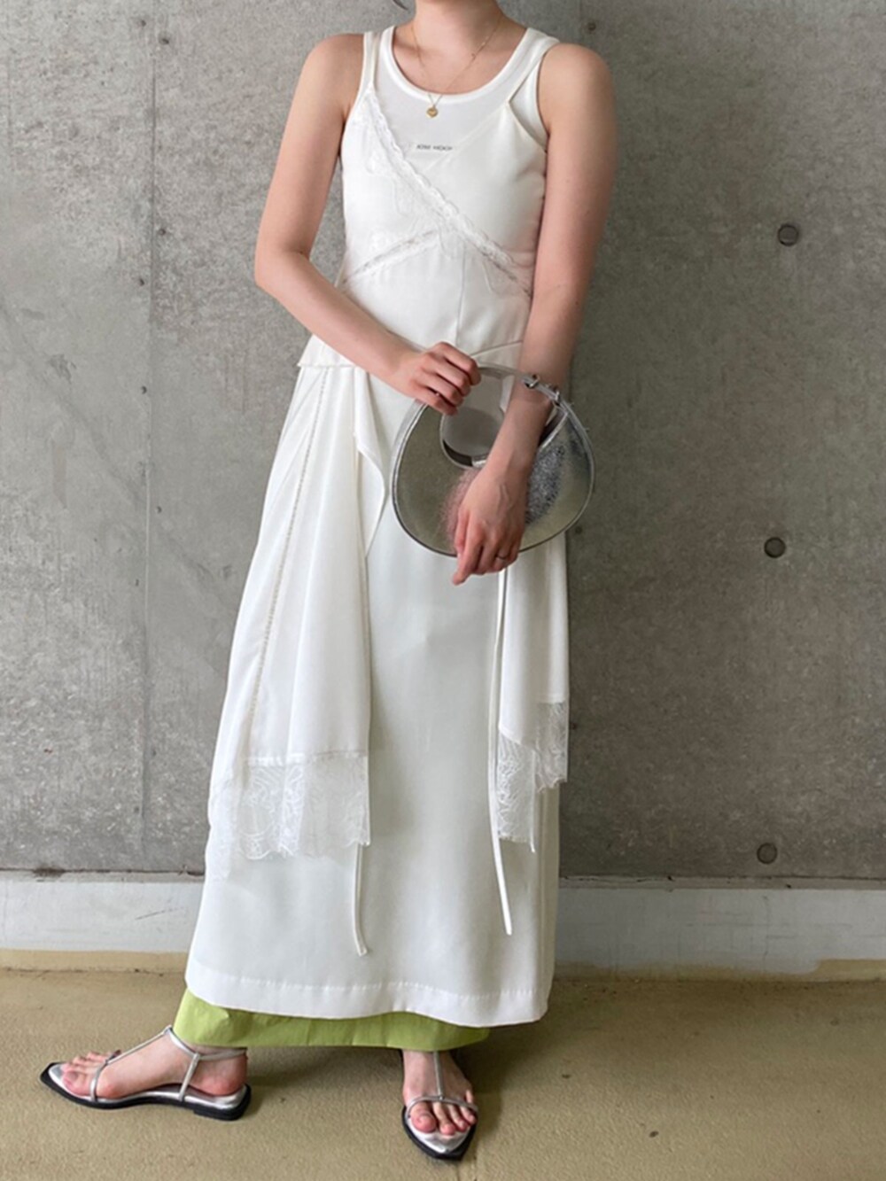 シルバー系のハンドバッグ、ホワイト系のタンクトップ、ホワイト系のワンピースを着用したレディースの夏コーディネートの2枚目の写真