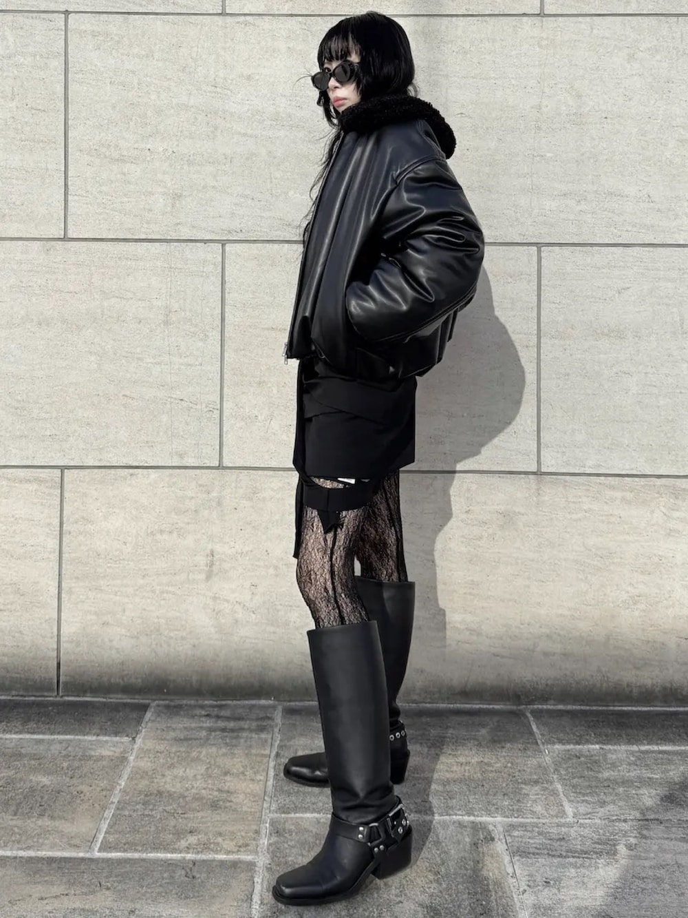 ブラック系のスカート、ブラック系のカーディガン/ボレロ、ブラック系のブルゾンを着用したレディースの冬コーディネートの2枚目の写真