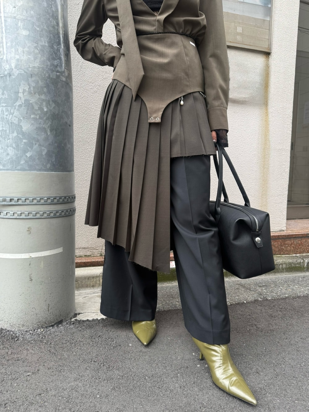 ブラック系のボストンバッグ、グリーン系のブーツ、ブラック系のスカートを着用したレディースの冬コーディネートの4枚目の写真