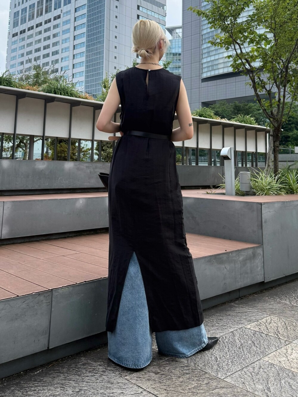 ブラック系のワンピース、ブルー系のデニムパンツ、ブラック系のハンドバッグを着用したレディースの夏コーディネートの3枚目の写真