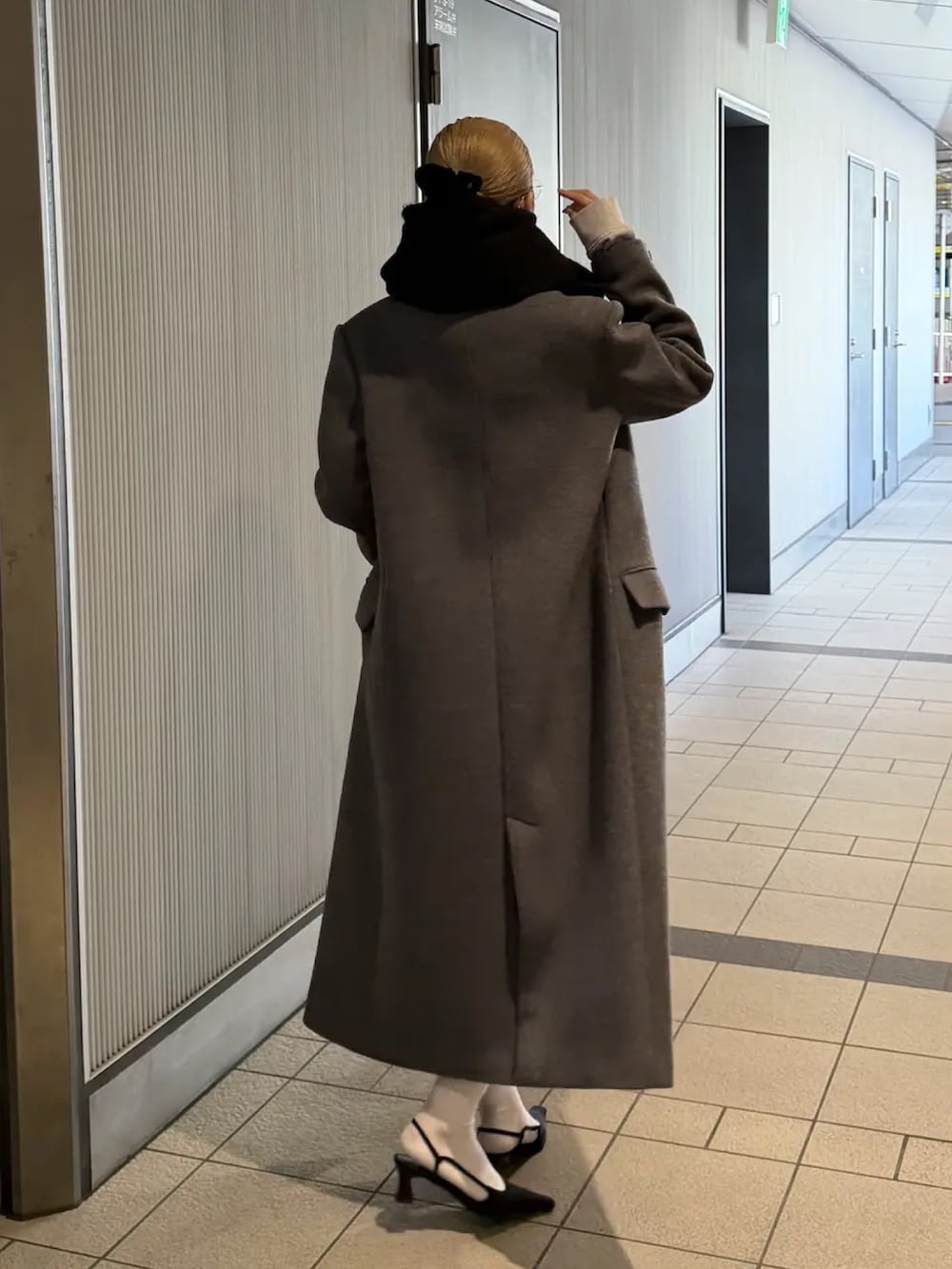 ブラック系のパンプス、グレー系のスカート、グレー系のスウェットを着用したレディースの冬コーディネートの3枚目の写真