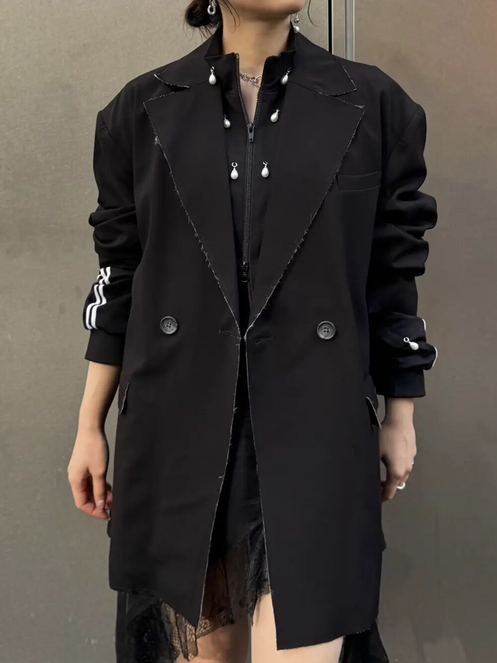 ブラック系のテーラードジャケット、ブラック系のジャージ、ブラック系のワンピースを着用したレディースの秋コーディネートの3枚目の写真