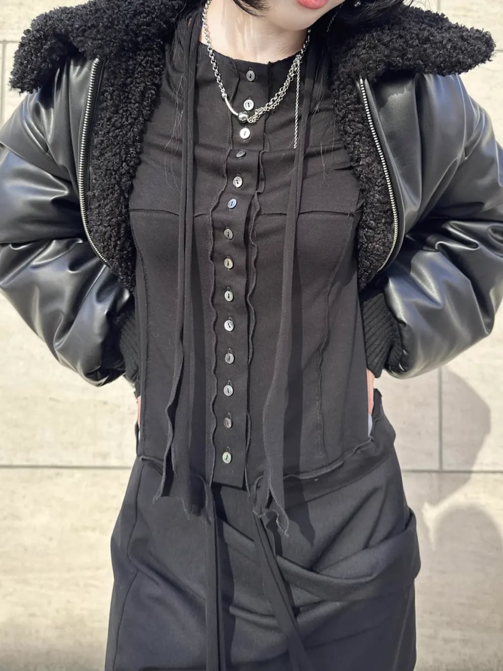 ブラック系のスカート、ブラック系のカーディガン/ボレロ、ブラック系のブルゾンを着用したレディースの冬コーディネートの3枚目の写真