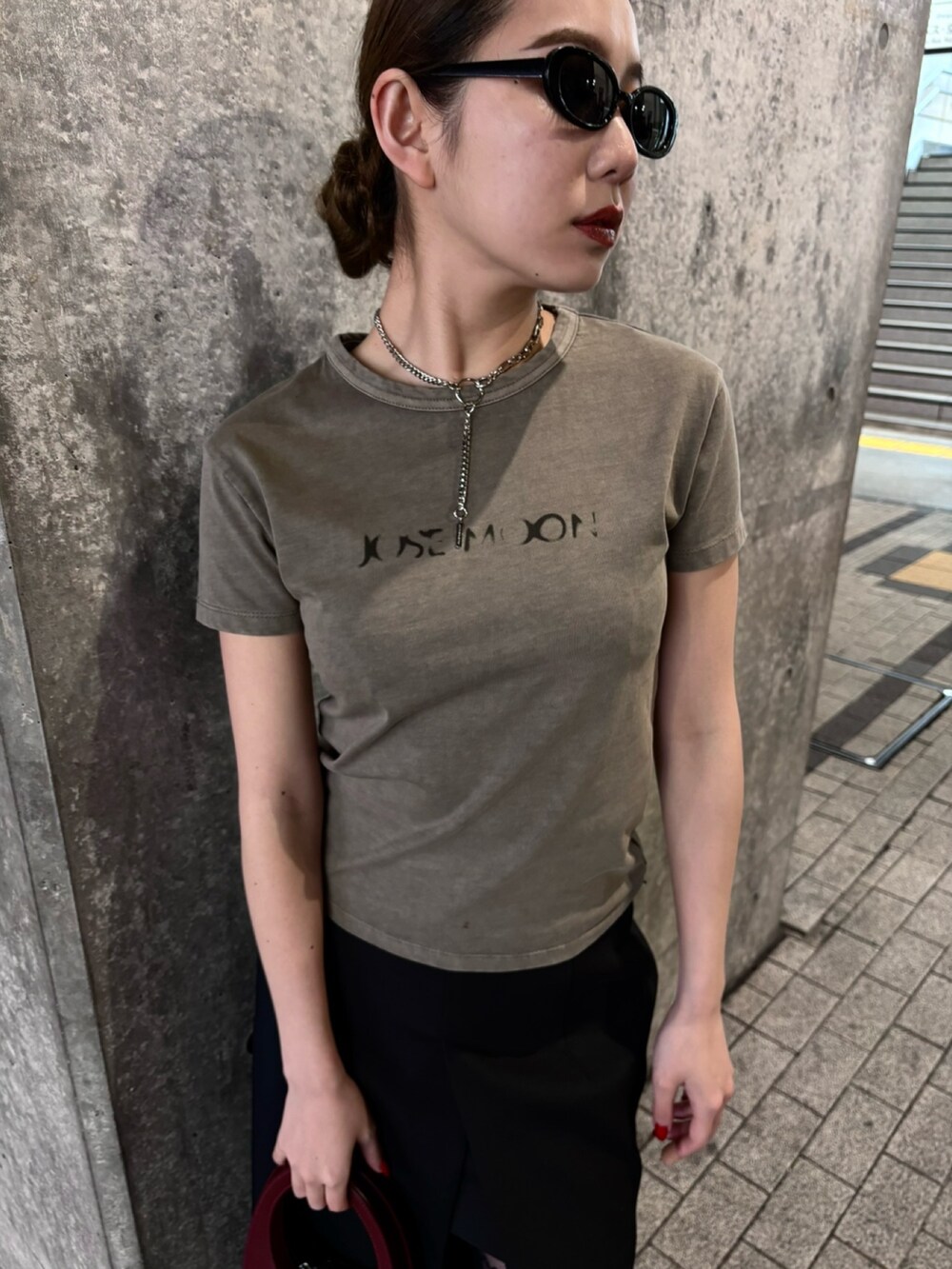 ブラウン系のTシャツ/カットソー、ブラック系のスカート、ブラック系のブーツを着用したレディースの春コーディネートの2枚目の写真
