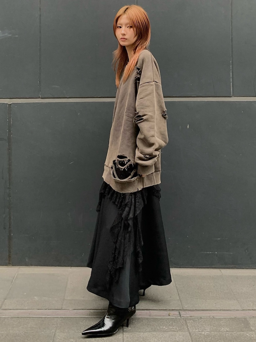 ブラウン系のスウェット、ブラック系のワンピース、ブラック系のスカートを着用したレディースの秋コーディネートの2枚目の写真