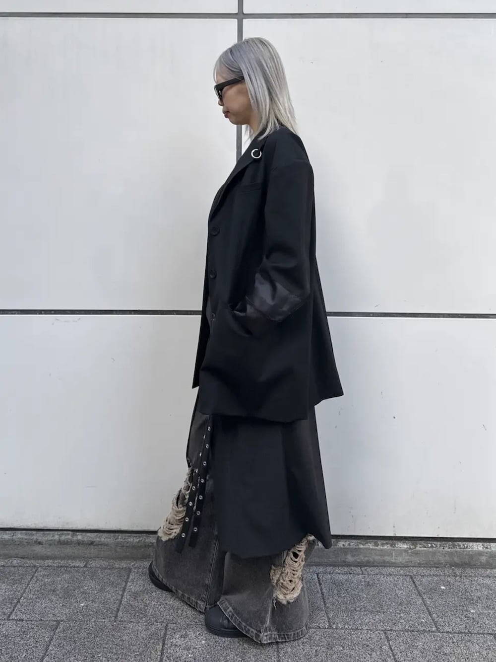 ブラック系のテーラードジャケット、ブラウン系のデニムパンツを着用したレディースの冬コーディネートの2枚目の写真