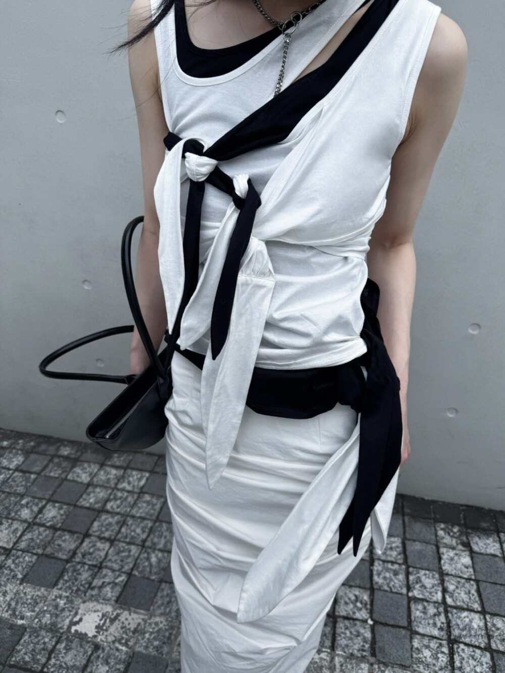 ブラック系のTシャツ/カットソー、ホワイト系のスカート、ホワイト系のTシャツ/カットソーを着用したレディースの夏コーディネートの4枚目の写真