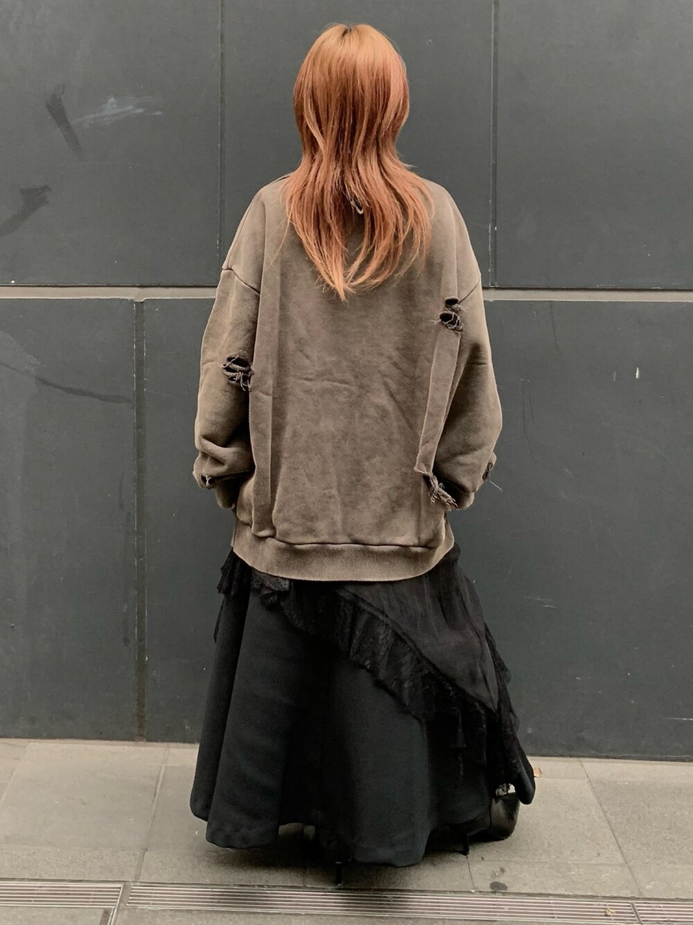 ブラウン系のスウェット、ブラック系のワンピース、ブラック系のスカートを着用したレディースの秋コーディネートの3枚目の写真