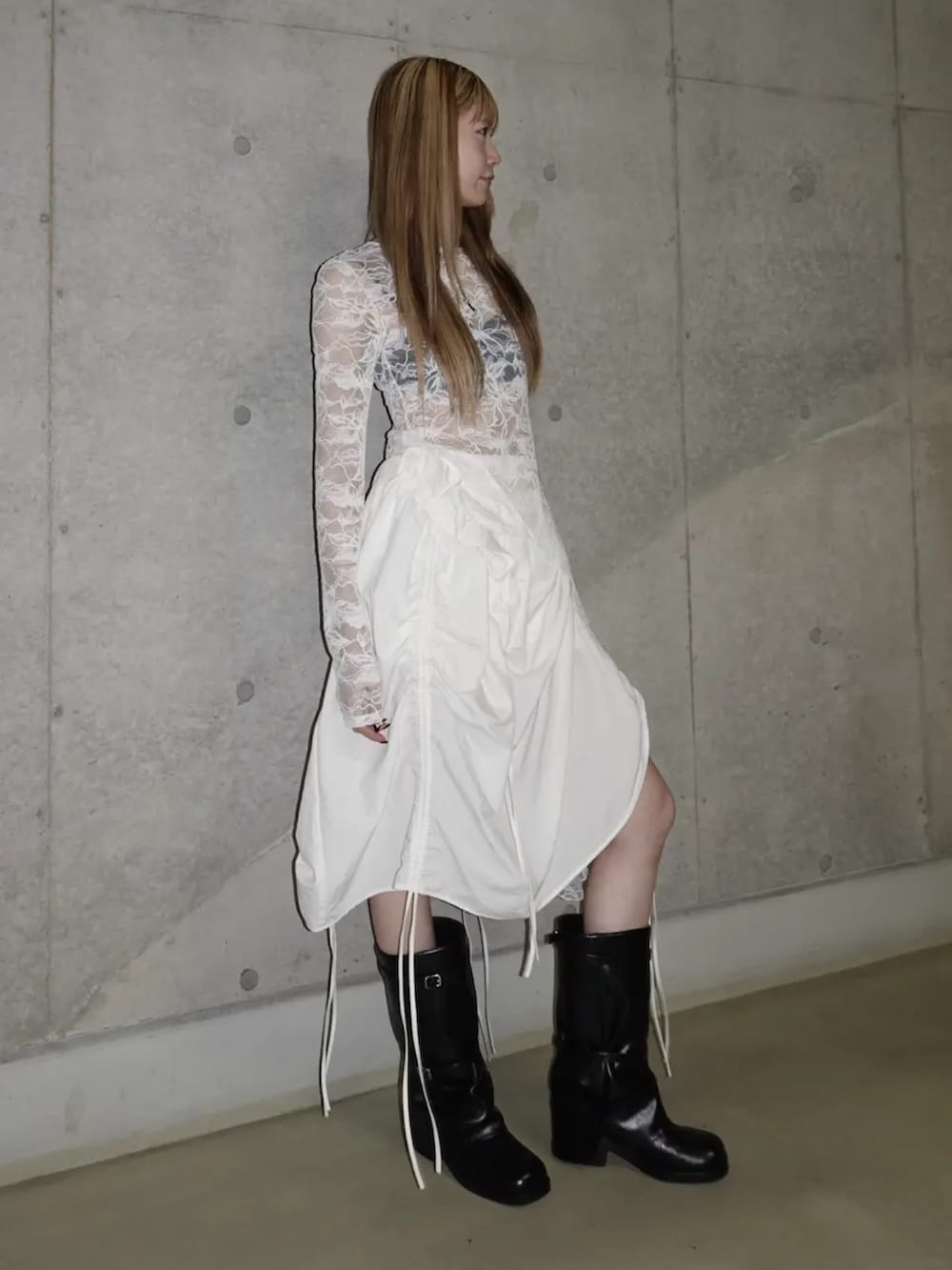 ホワイト系のTシャツ/カットソー、ホワイト系のスカート、ブラック系のブーツを着用したレディースの春コーディネートの2枚目の写真