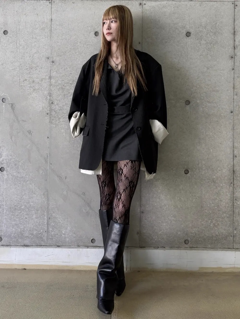 グレー系のテーラードジャケット、ブラック系のドレスを着用したレディースの冬コーディネートの2枚目の写真