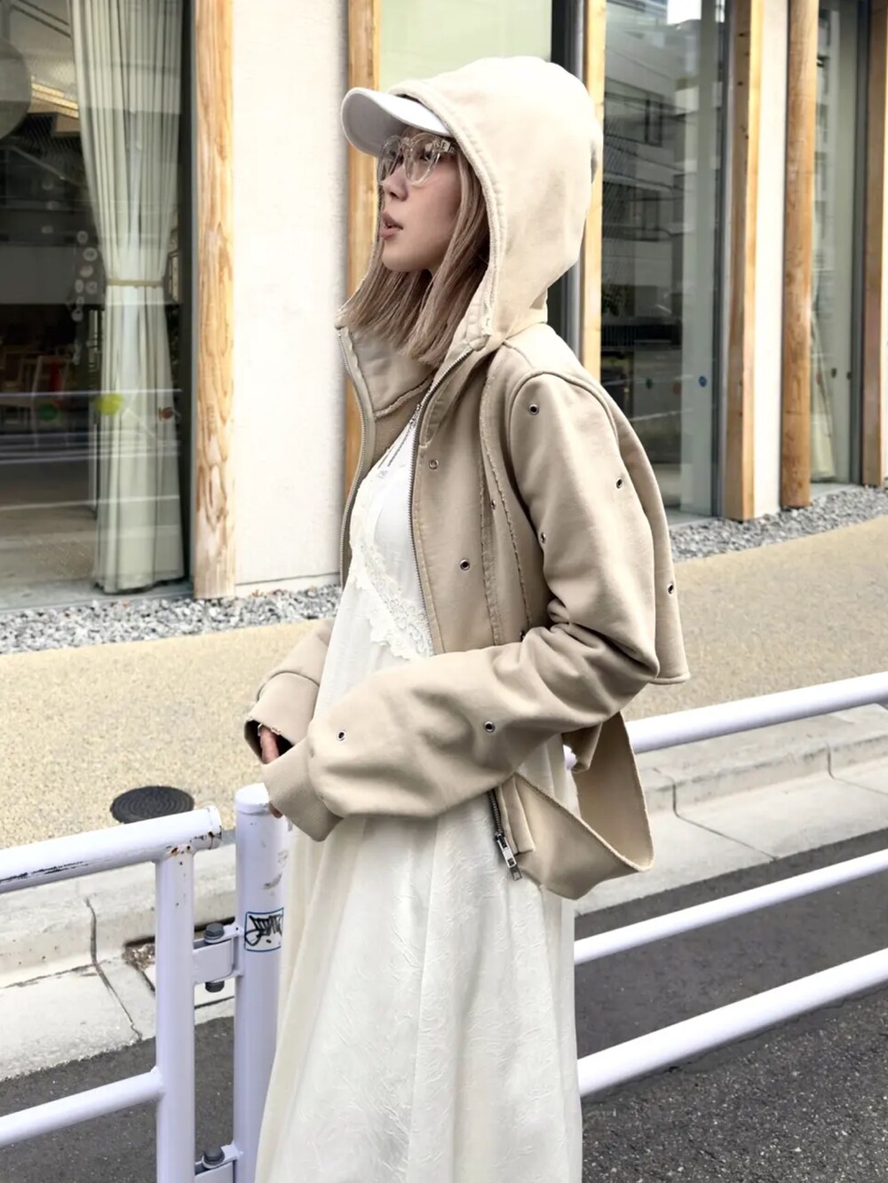 ホワイト系のタンクトップ、ベージュ系のパーカー、ホワイト系のワンピースを着用したレディースの冬コーディネートの2枚目の写真