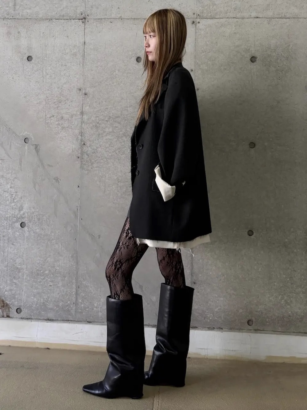 グレー系のテーラードジャケット、ブラック系のドレスを着用したレディースの冬コーディネートの3枚目の写真