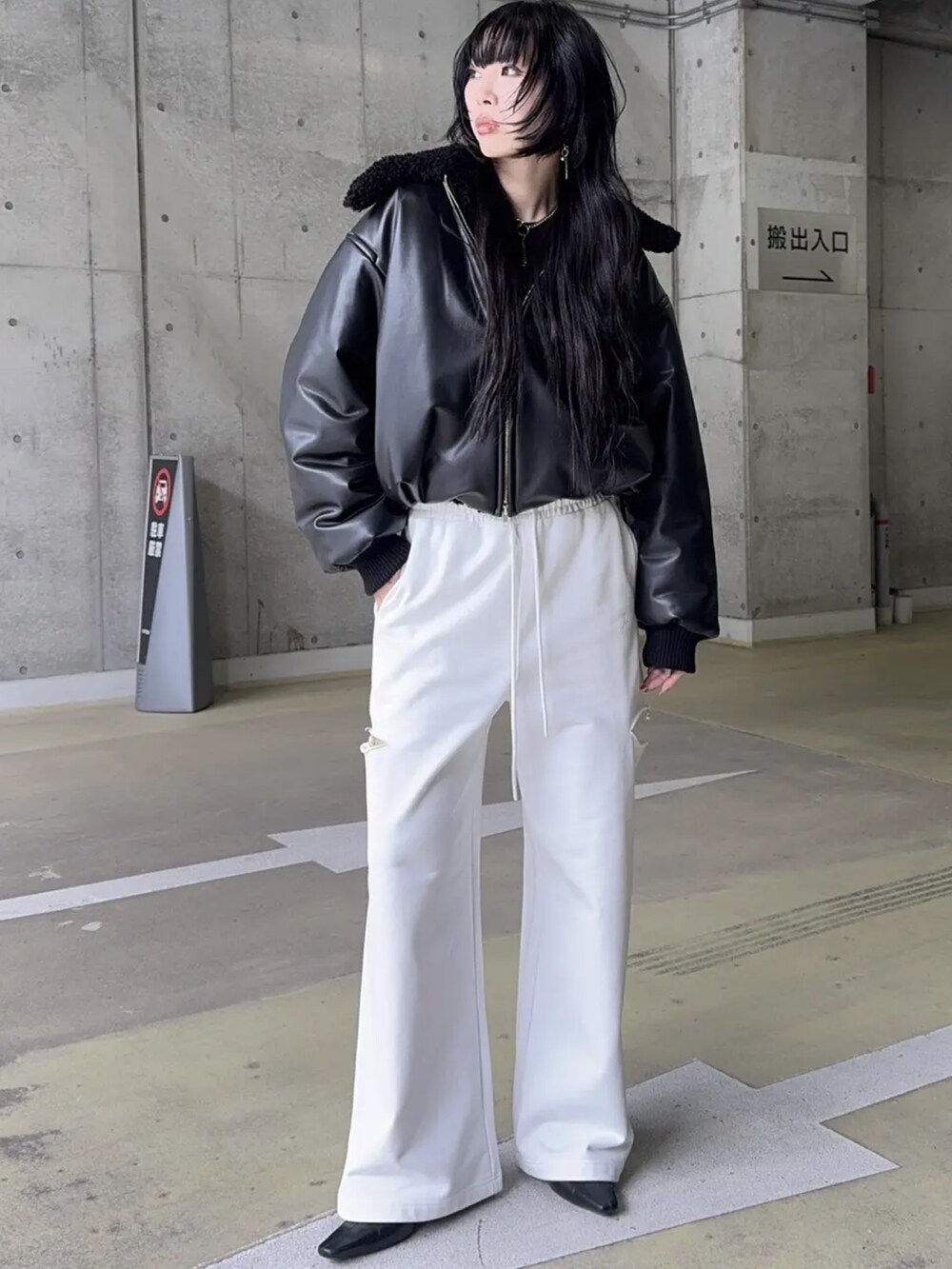 ブラック系のブルゾン、ホワイト系のスウェットパンツを着用したレディースの冬コーディネートの2枚目の写真