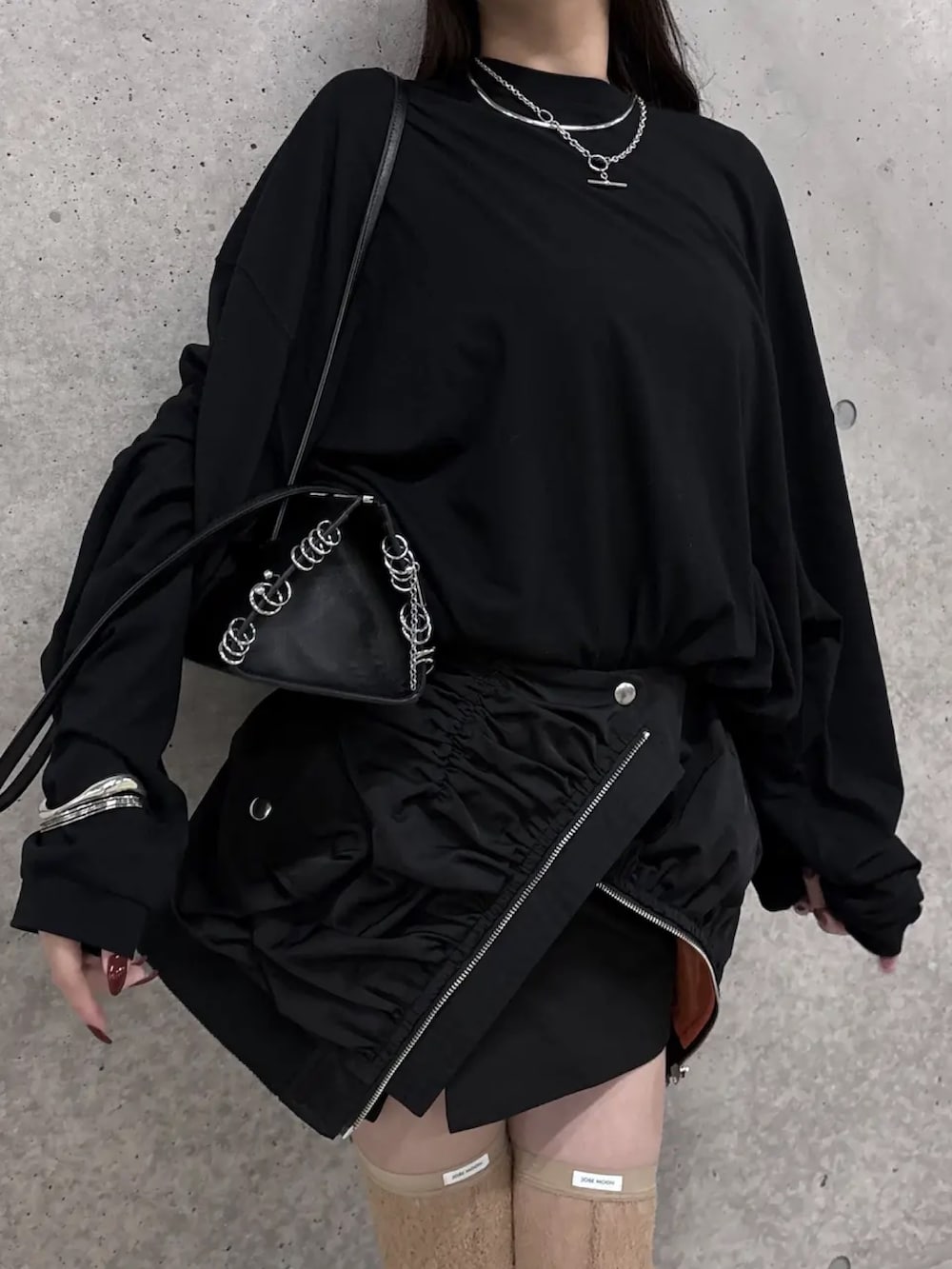 ブラック系のスカート、ブラック系のTシャツ/カットソー、ベージュ系のソックス/靴下を着用したレディースの冬コーディネートの4枚目の写真