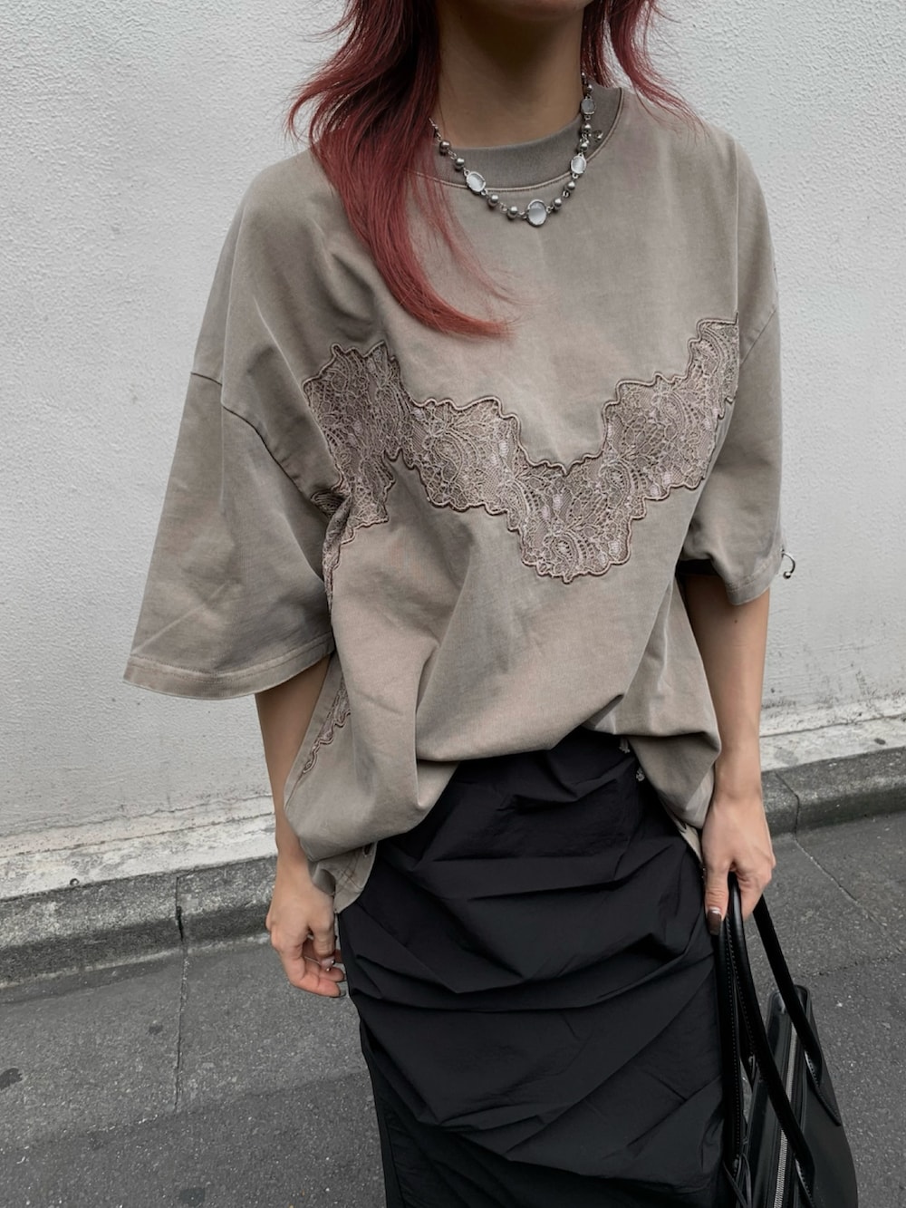 ベージュ系のTシャツ/カットソー、ブラック系のスカートを着用したレディースの夏コーディネートの5枚目の写真