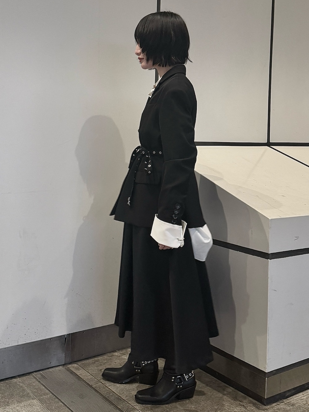 ブラック系のスカート、ブラック系のテーラードジャケット、ホワイト系のシャツ/ブラウスを着用したレディースの秋コーディネートの3枚目の写真