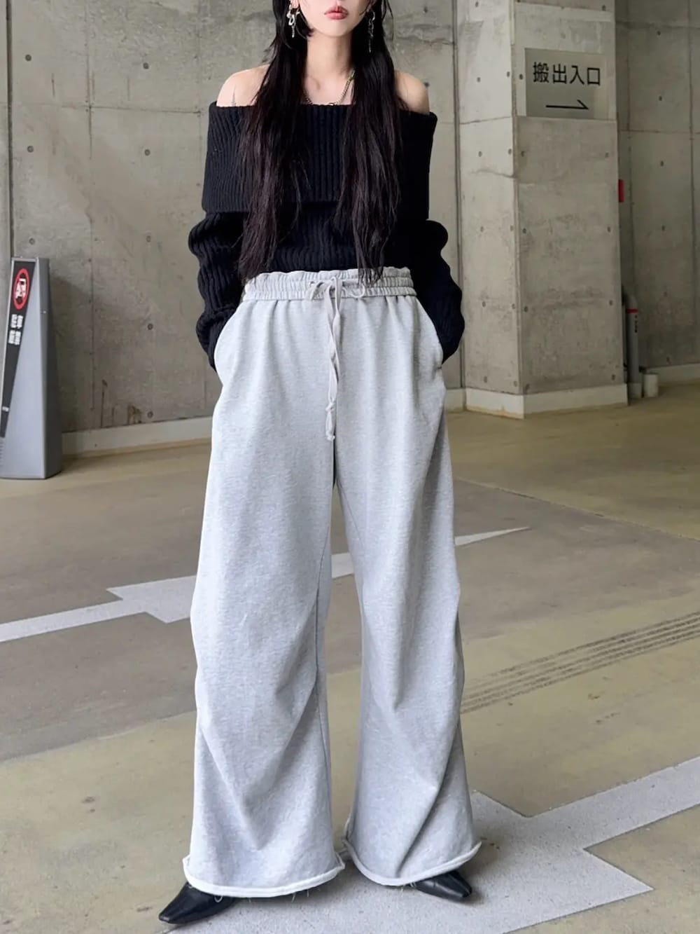 グレー系のスウェットパンツ、ブラック系のニット/セーターを着用したレディースの冬コーディネートの2枚目の写真