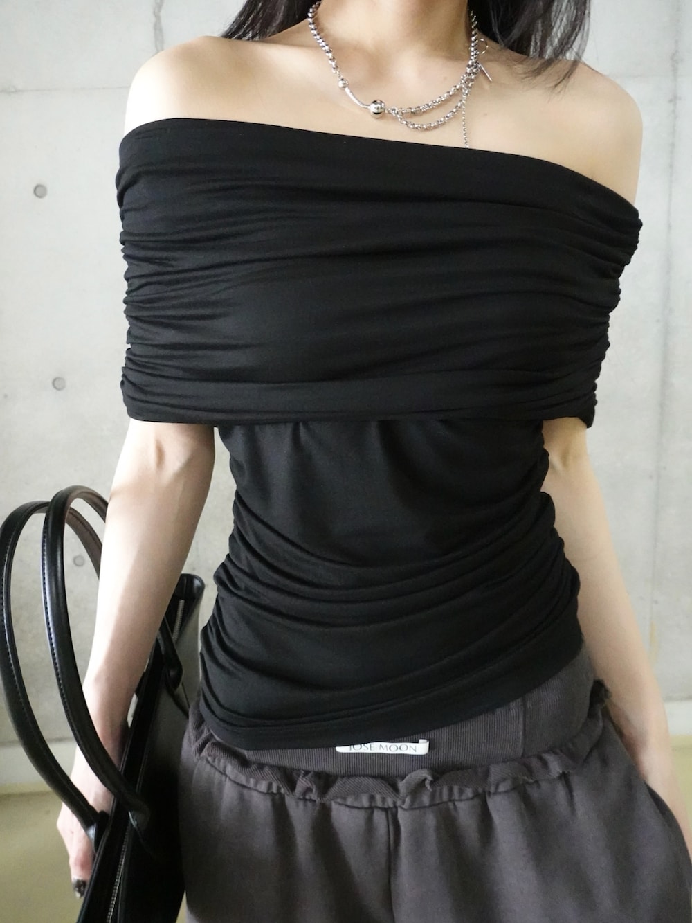 ブラック系のTシャツ/カットソー、ブラック系のハンドバッグ、グレー系のスウェットパンツを着用したレディースの夏コーディネートの3枚目の写真