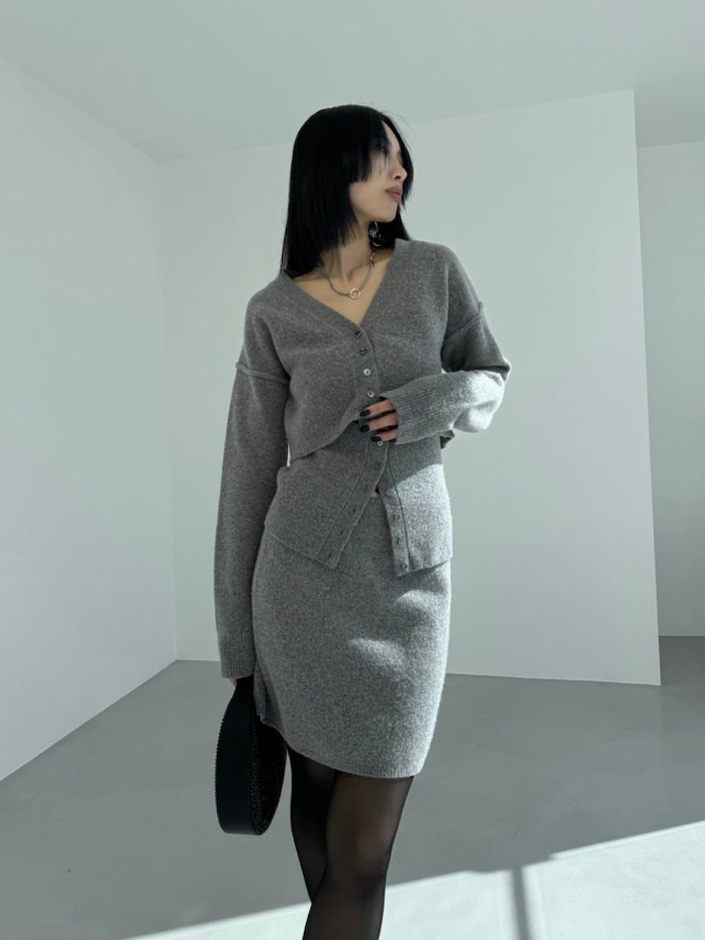 グレー系のカーディガン/ボレロ、ブラック系のハンドバッグ、ブラック系のパンプスを着用したレディースの春コーディネートの3枚目の写真