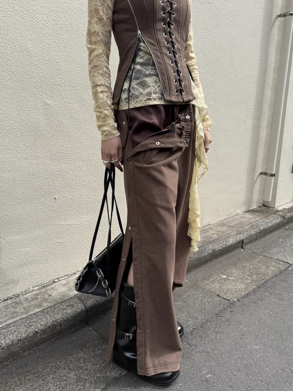 ブラウン系のスウェットパンツ、ブラック系のブーツ、ブラウン系のその他トップスを着用したレディースの春コーディネートの5枚目の写真