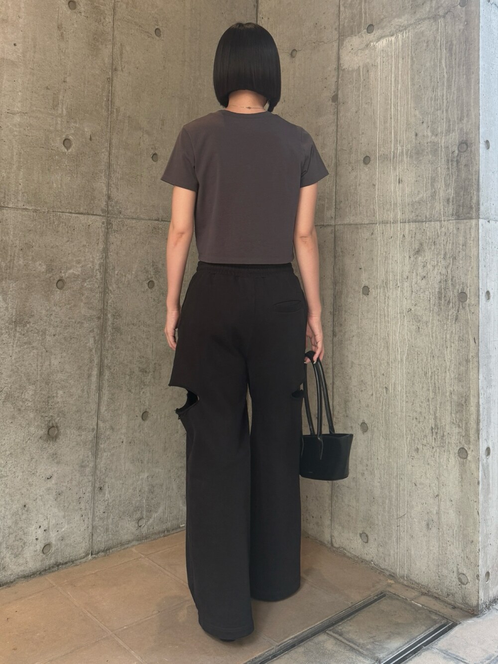 グレー系のTシャツ/カットソー、ブラック系のスウェットパンツを着用したレディースの秋コーディネートの3枚目の写真