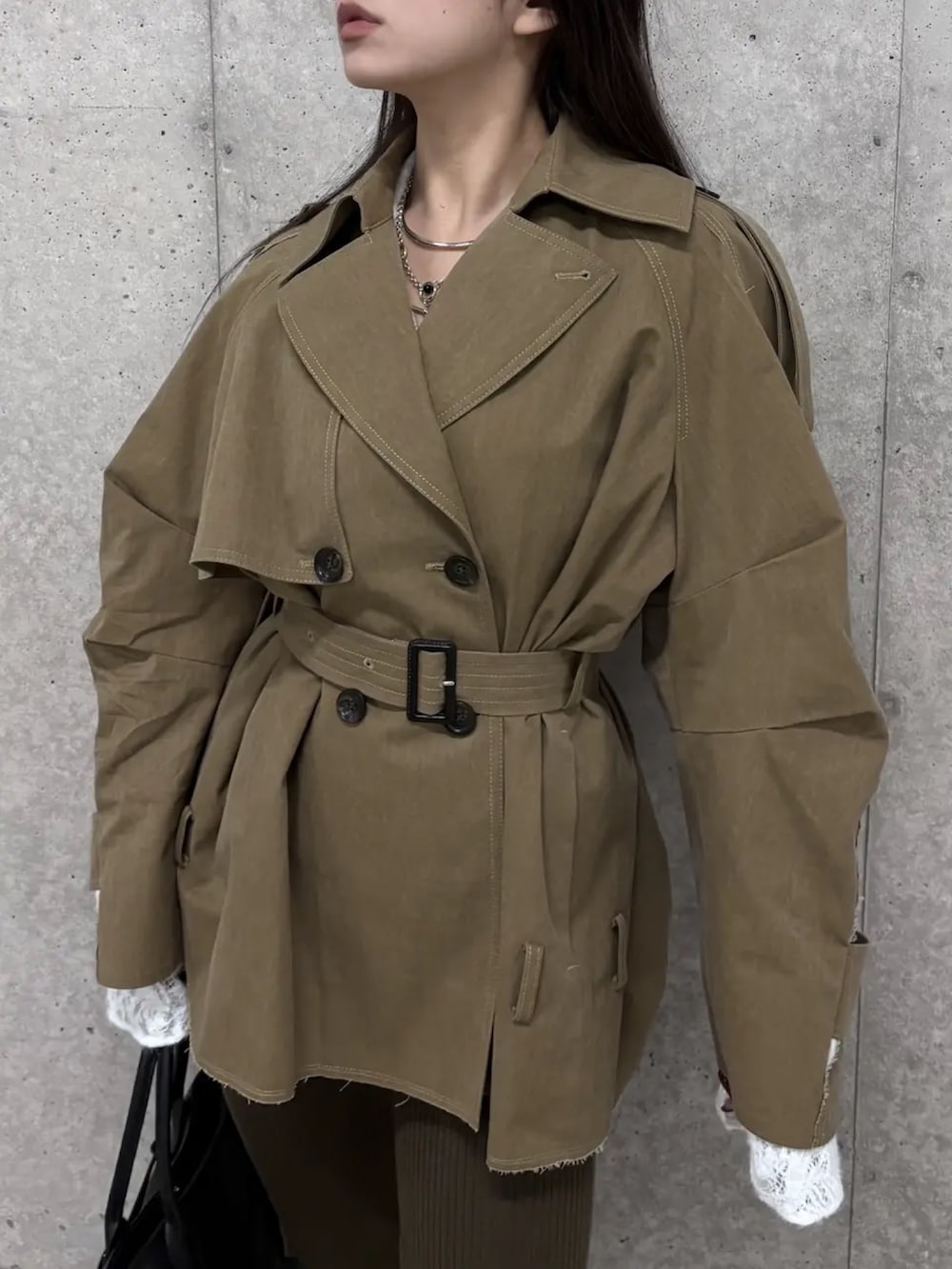 ベージュ系のトレンチコート、ホワイト系のシャツ/ブラウス、ブラック系のボストンバッグを着用したレディースの冬コーディネートの3枚目の写真