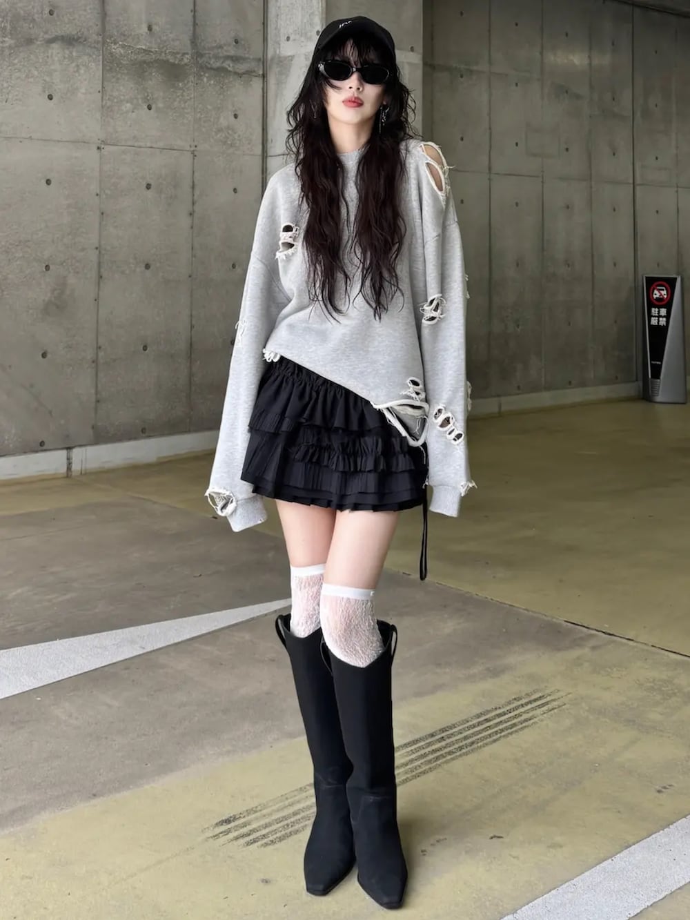 ブラック系のスカート、ブラック系のブーツ、グレー系のスウェットを着用したレディースの冬コーディネートの2枚目の写真