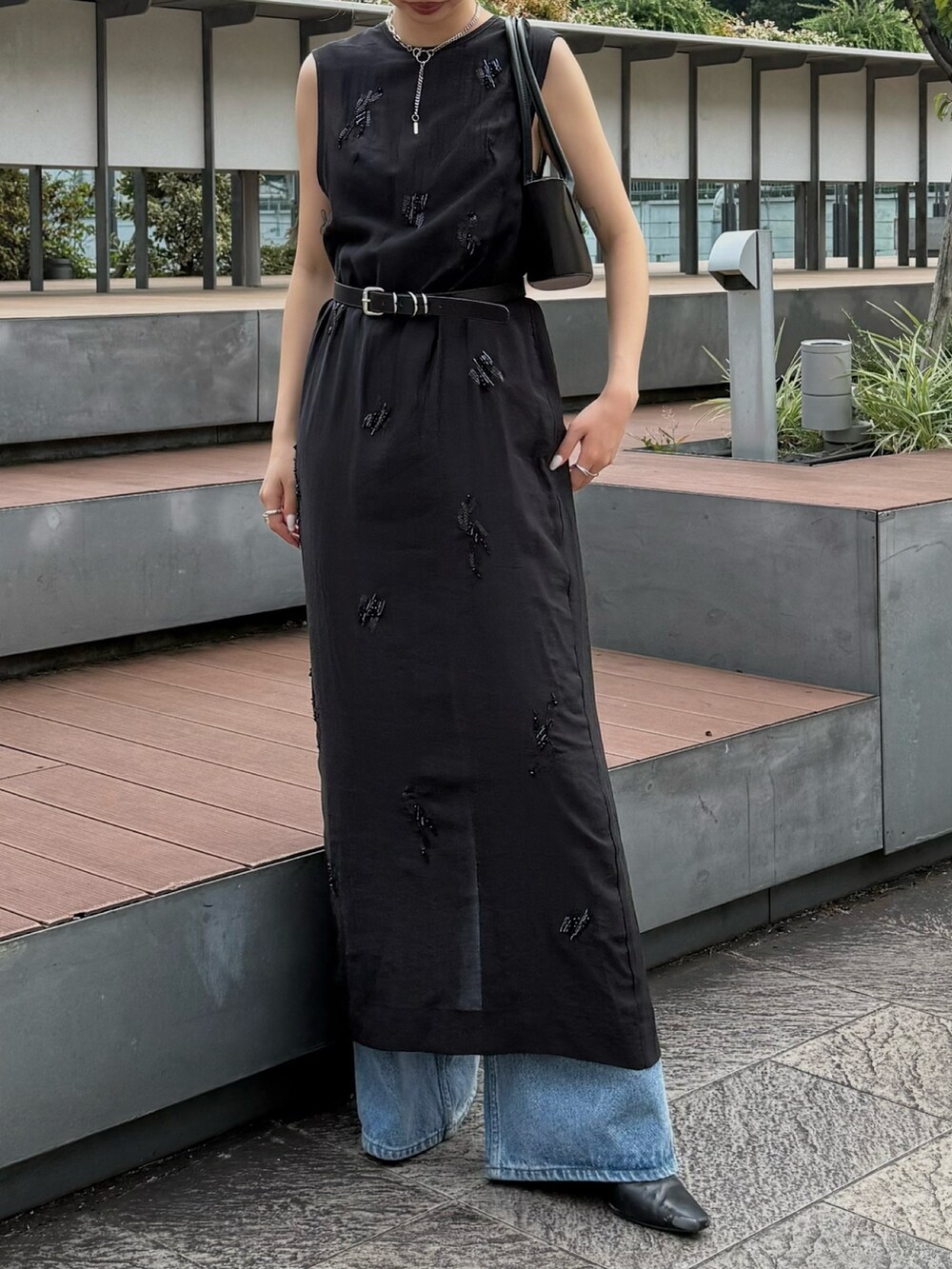 ブラック系のワンピース、ブルー系のデニムパンツ、ブラック系のハンドバッグを着用したレディースの夏コーディネートの4枚目の写真