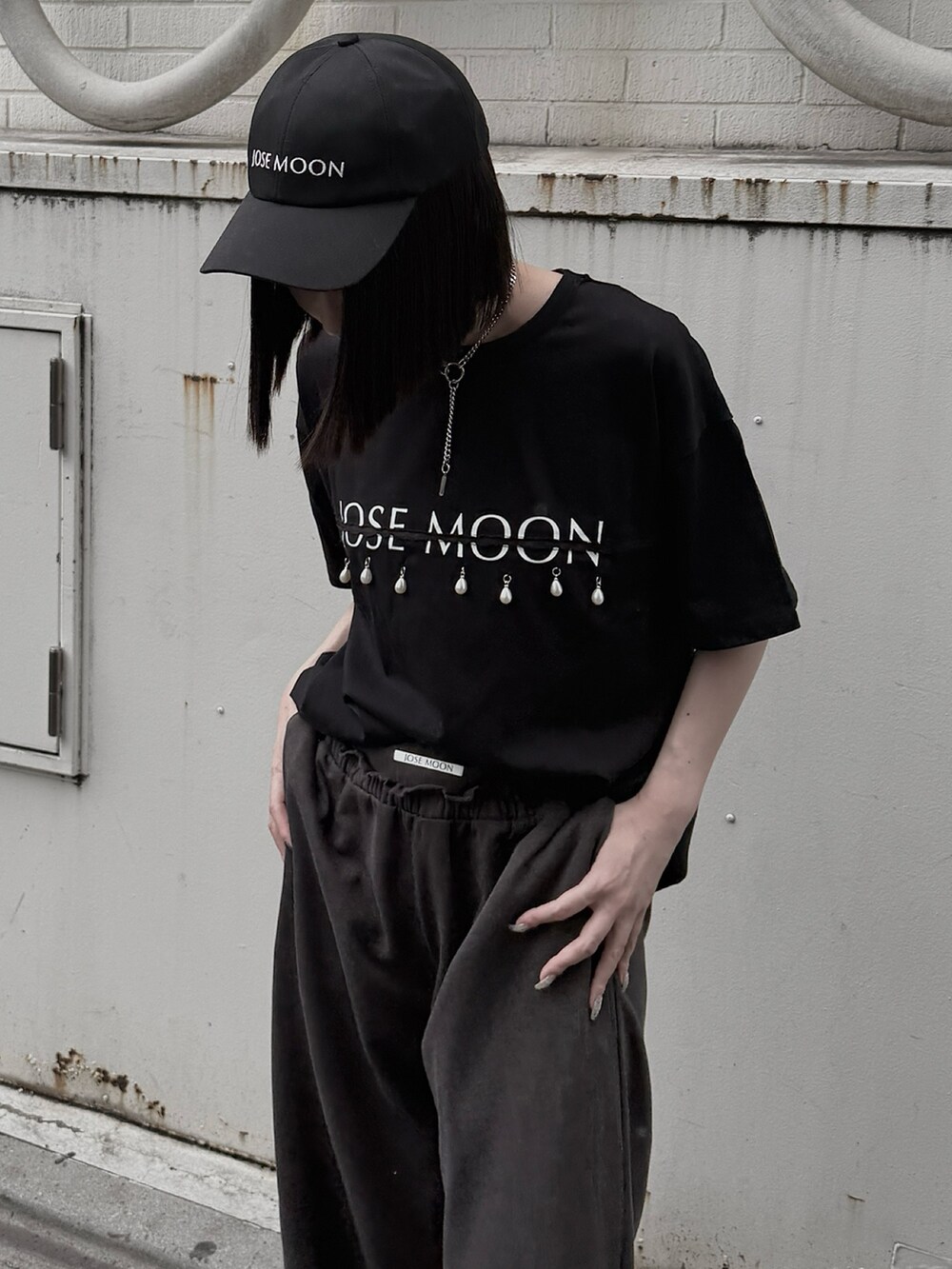 ブラック系のTシャツ/カットソー、グレー系のスウェットパンツ、ブラック系のキャップを着用したレディースの夏コーディネートの3枚目の写真