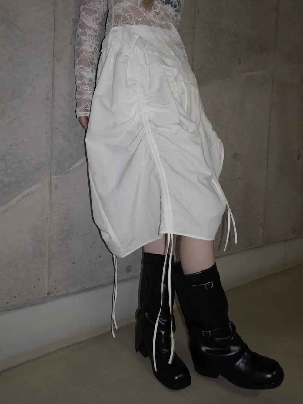 ホワイト系のTシャツ/カットソー、ホワイト系のスカート、ブラック系のブーツを着用したレディースの春コーディネートの4枚目の写真