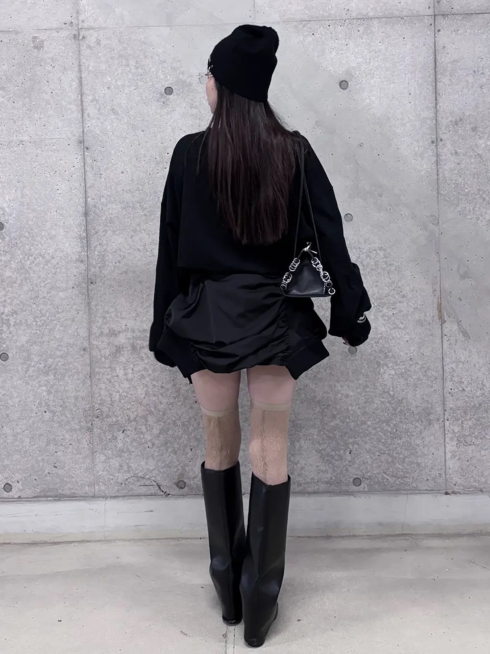 ブラック系のスカート、ブラック系のTシャツ/カットソー、ベージュ系のソックス/靴下を着用したレディースの冬コーディネートの3枚目の写真