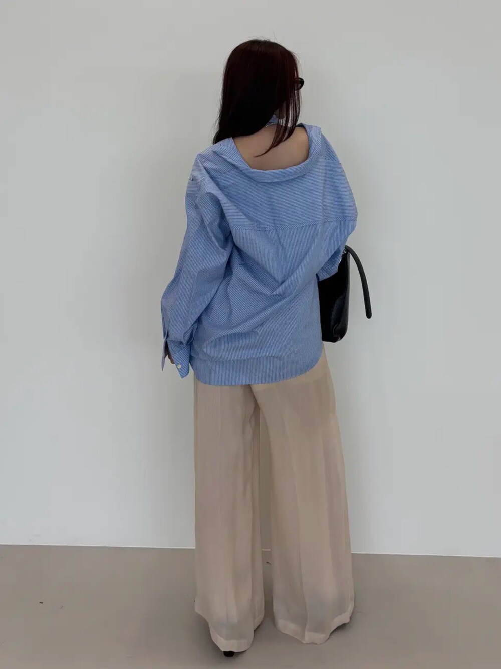 ブルー系のシャツ/ブラウスを着用したレディースの秋コーディネートの2枚目の写真