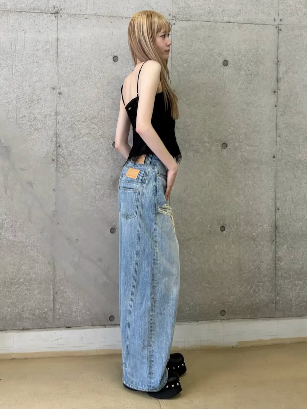 ブラック系のその他トップス、ブルー系のデニムパンツ、ブラック系のブーツを着用したレディースの夏コーディネートの2枚目の写真