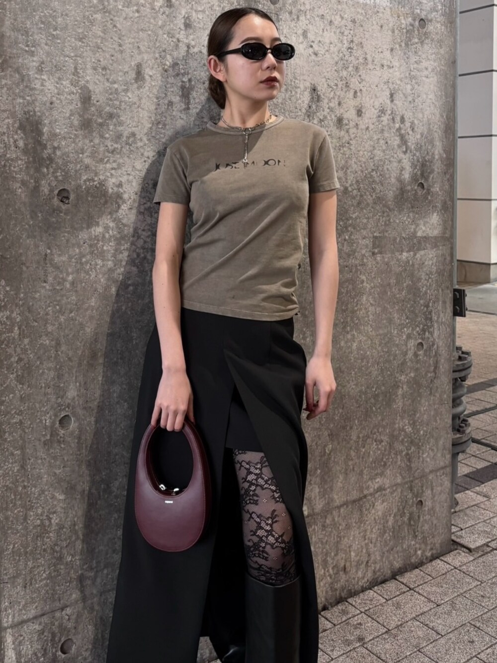 ブラウン系のTシャツ/カットソー、ブラック系のスカート、ブラック系のブーツを着用したレディースの春コーディネートの3枚目の写真