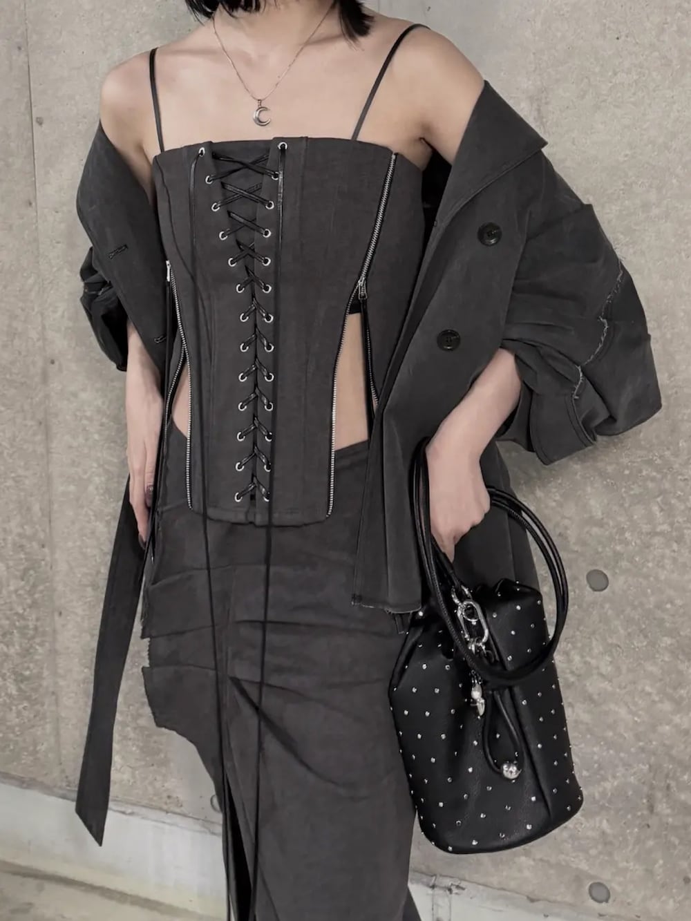 ブラック系のその他トップス、グレー系のトレンチコート、ブラック系のスカートを着用したレディースの春コーディネートの3枚目の写真