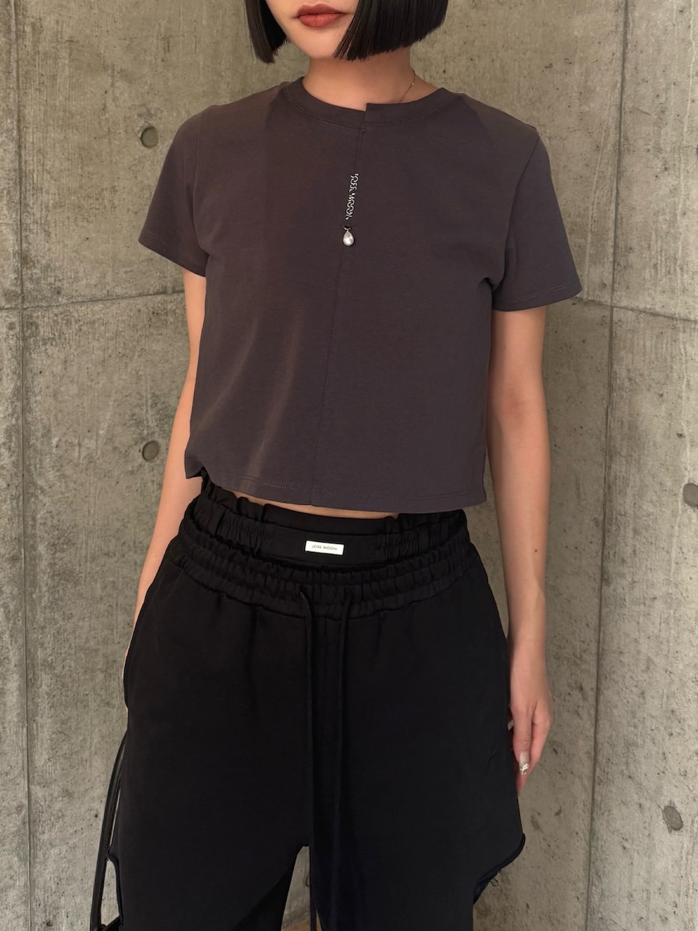 グレー系のTシャツ/カットソー、ブラック系のスウェットパンツを着用したレディースの秋コーディネートの4枚目の写真