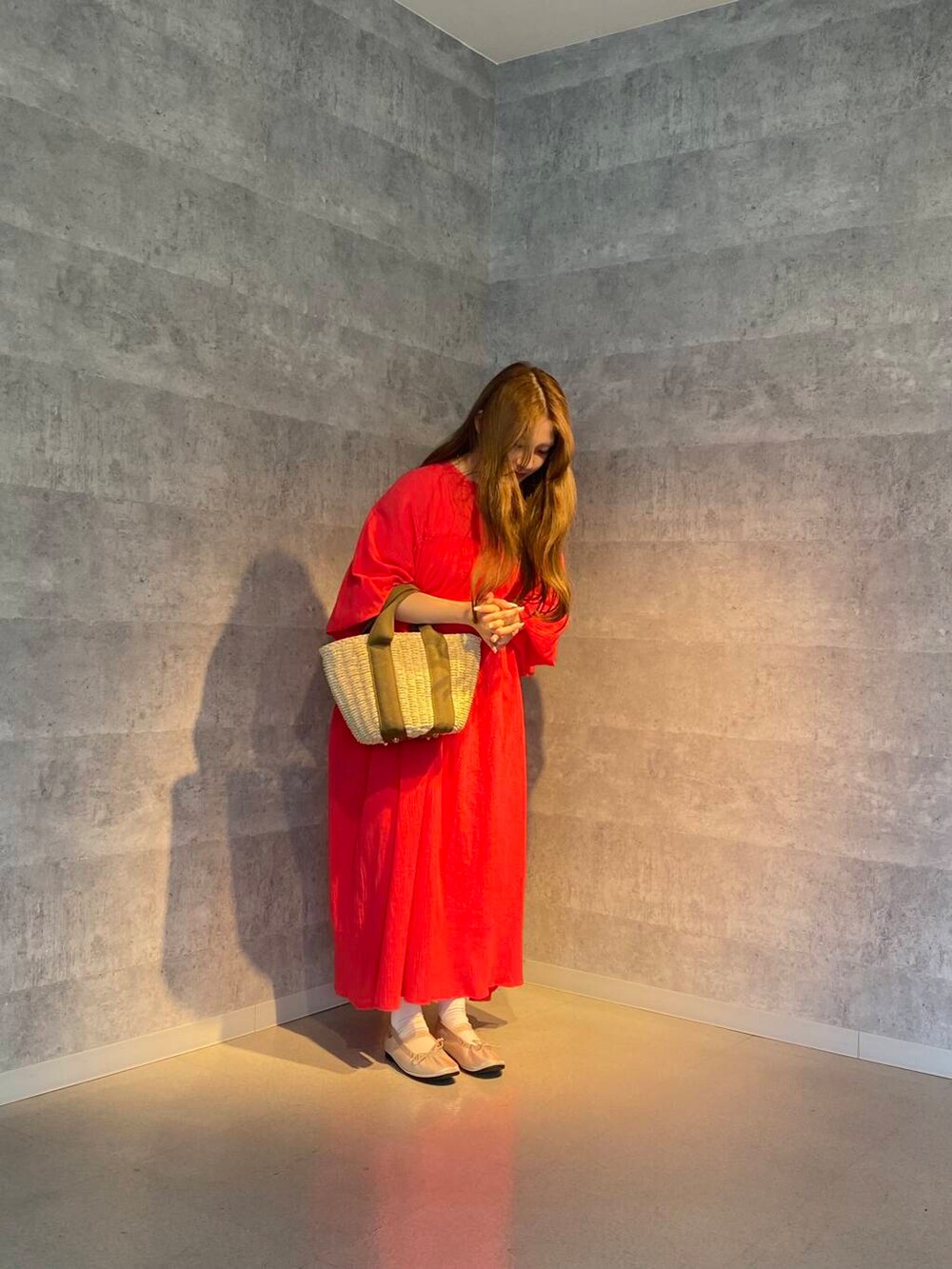 ベージュ系のかごバッグ、ホワイト系のワンピース、レッド系のワンピースを着用したレディースの夏コーディネートの2枚目の写真