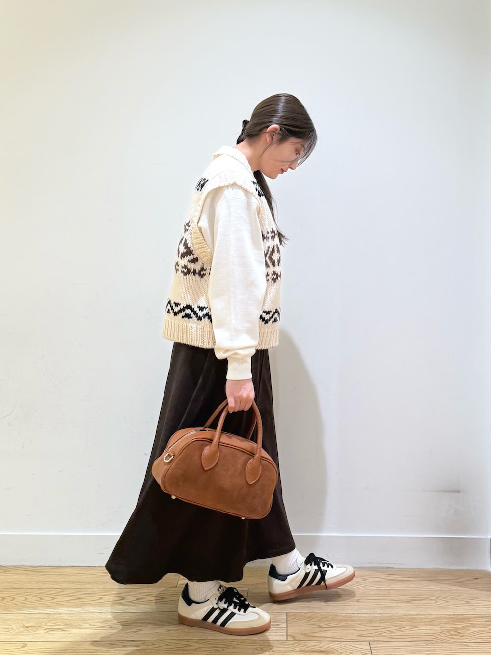 ホワイト系のベスト、ホワイト系のニット/セーター、ブラウン系のスカートを着用したレディースの秋コーディネートの5枚目の写真